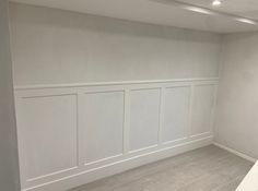 an empty room with white paneling on the walls