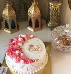 a decorated cake sitting on top of a table next to other decorative objects and candles