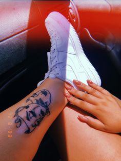 a woman's foot with a tattoo on her left leg and an air jordan shoe