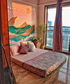 a bedroom with a large painting on the wall next to a bed in front of a window