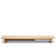 a wooden shelf sitting on top of a white wall