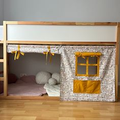 a bunk bed with a yellow and white quilt on the bottom half, next to a small child's bed