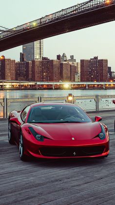 two red sports cars parked next to each other in front of a large city skyline