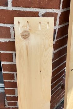 a piece of wood sitting on the side of a brick wall next to a door