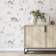 a wallpaper with cows and grass on it in a room that has wooden flooring