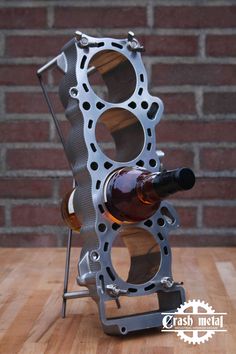 an engine block with a bottle of wine in it on top of a wooden table