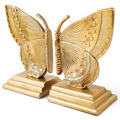 two gold butterfly sculptures sitting on top of each other