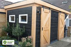 a black shed with wooden doors and windows