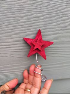 a person is holding a red origami star