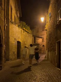 three people walking down an alley way at night