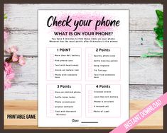 the printable check your phone game is displayed on a wooden table with pink flowers