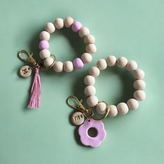 two white and pink bracelets with tassels on them sitting next to each other