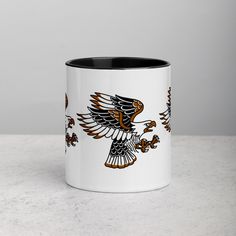 a white and black coffee mug with an eagle on it