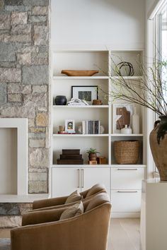 a living room filled with furniture and a stone fireplace