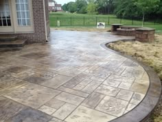 an outdoor patio with stone steps and seating area in the back yard, next to a brick building