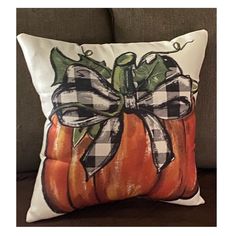 a decorative pumpkin pillow with a bow on it's front sitting on a couch