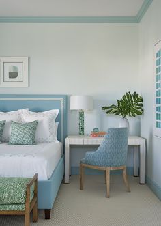 a bed room with a neatly made bed next to a chair and table in front of it