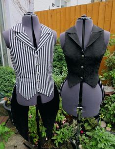 two mannequins dressed in black and white striped vests are standing next to each other