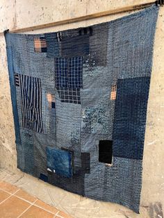 a blue quilt hanging from the side of a wall