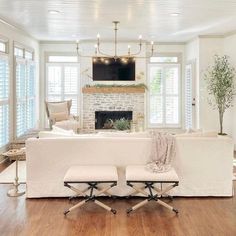 a living room filled with furniture and a flat screen tv mounted on the wall above a fireplace