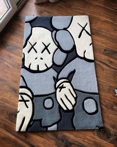 a rug with an image of two cartoon characters on it, in front of a window