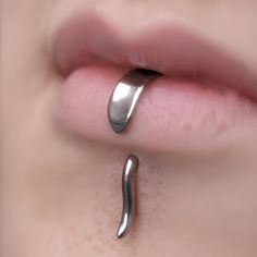 a woman's nose with a metal object attached to the side of her lip