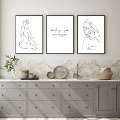 three framed art prints on a wall above a sink