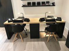 two black chairs sitting at a table with some hair dryers on it