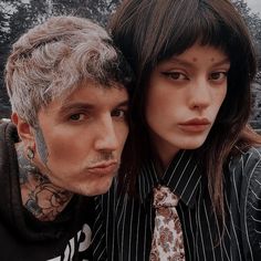 a man and woman with tattoos on their faces