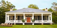 a white house sitting on top of a lush green field