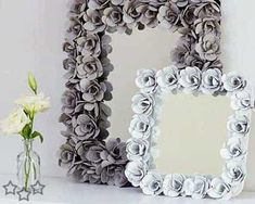 two decorative mirrors sitting next to each other on a shelf with flowers in vases