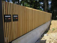 a wooden fence that is next to a wall with two buttons on the front and one button on the back