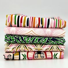 four different colored fabrics stacked on top of each other, one in the middle and one in the back