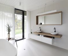 a white bathroom with two sinks and a bathtub next to a sliding glass door