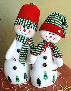 two snowmen are standing next to each other