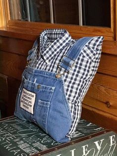 a denim bag sitting on top of a stack of books