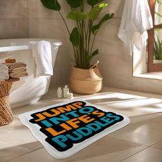 a bathroom area with a toilet, bathtub and towels on the floor next to a plant