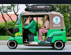 a man and woman riding on the back of a green bus