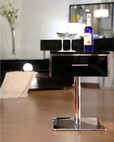 two wine glasses sitting on top of a black table next to a bottle of wine