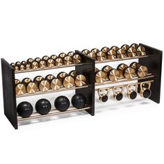 two black and gold shelves holding various pairs of exercise balls, kettles and bells