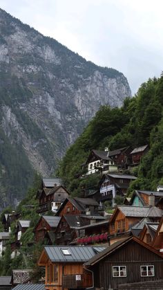 the mountains are covered with trees and houses in the foreground, along with buildings on either side