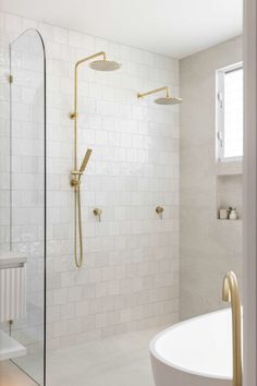 a bathroom with a tub, shower head and white tiled walls is shown in this image