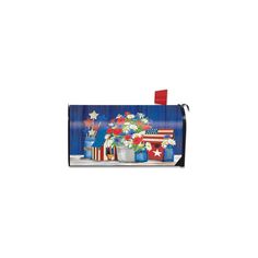 an american flag mailbox cover with flowers and patriotic decorations on the front, along with red white and blue flags