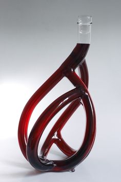 a red and black glass sculpture on a white background