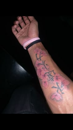 a man's arm with pink flowers on it