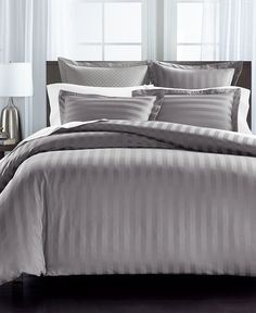 a bed with grey and white striped comforter