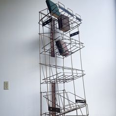 a tall metal structure with several pieces of luggage on it's top and bottom