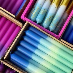 several different colored candles in boxes with glitter on them and one is blue, the other has yellow