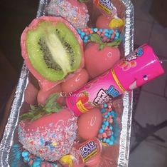 an assortment of fruit and candy in a tray