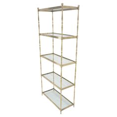 a gold metal shelf with glass shelves on each side and three tiers in the middle